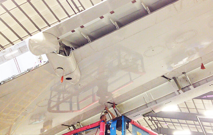 Aircraft mechanic installing panels on a Boeing 757 wing.